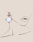 d-by-dalia-jewelry circular drop earrings with white discs, neutral faceted stones, and gold-tone crystal accents.