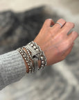 d-by-dalia-jewelry multi-layered silver chain bracelet with a central knotted detail worn on a wrist.