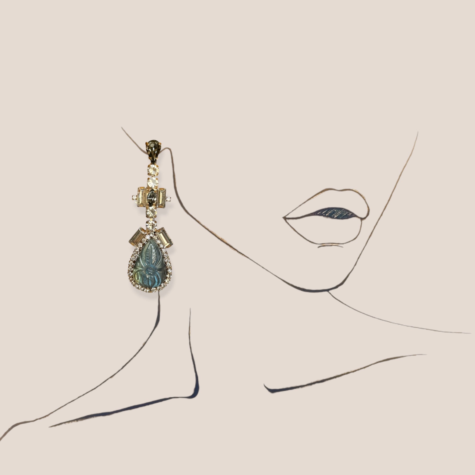 d-by-dalia-jewelry statement drop earrings featuring a carved teardrop gemstone, crystal halo, and metallic setting.