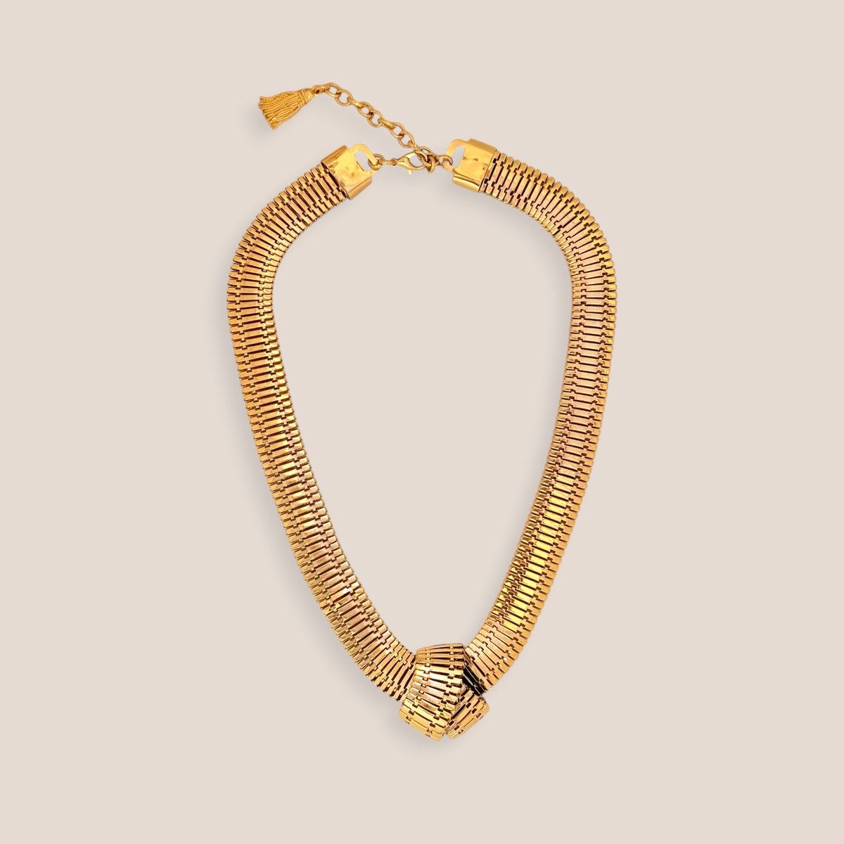 d-by-dalia-jewelry gold-toned statement necklace with an intricate mesh-link design and a central knot detail.