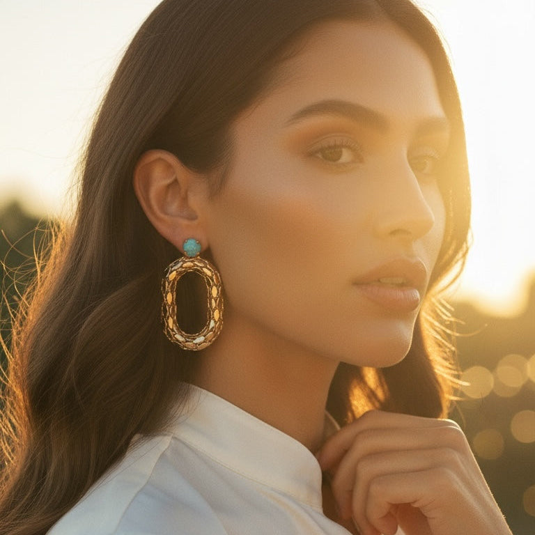 d-by-dalia-jewelry oval link statement earrings in textured gold with a turquoise crystal accent worn by a model