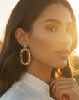 d-by-dalia-jewelry oval link statement earrings in textured gold with a turquoise crystal accent worn by a model