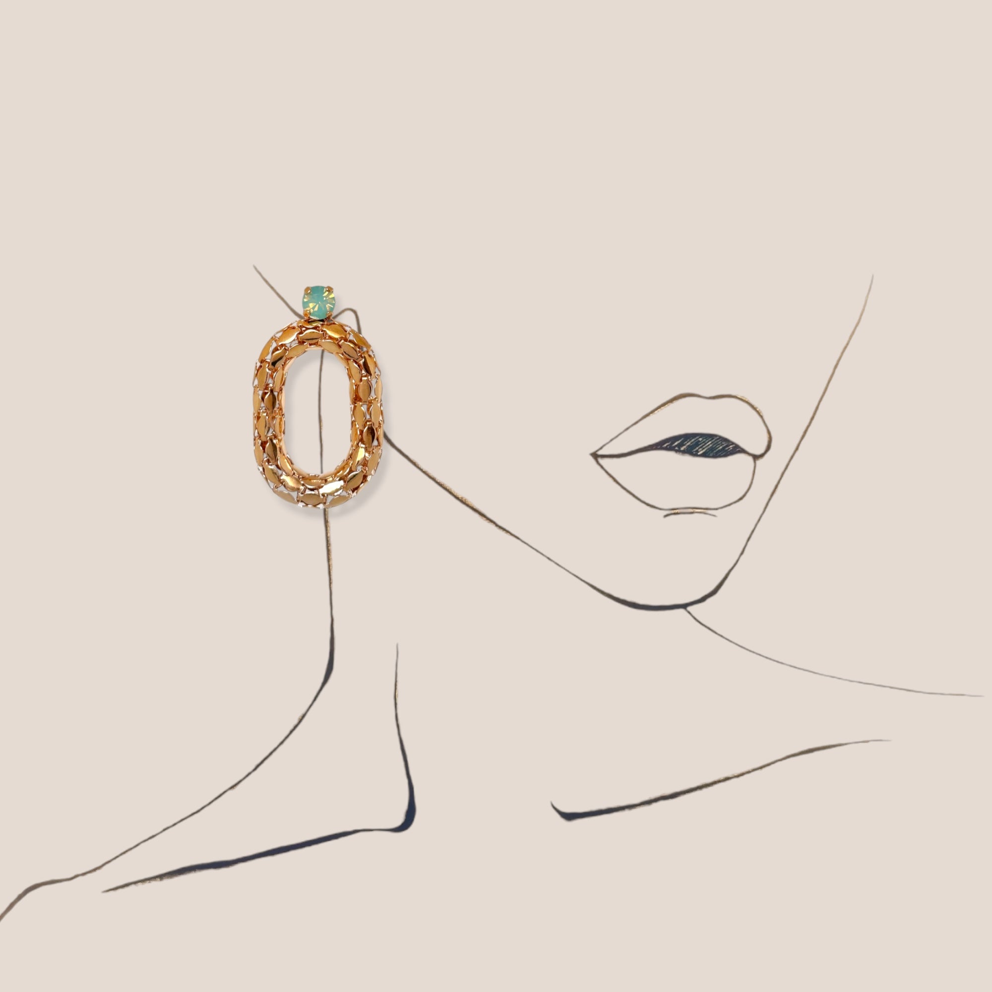 d-by-dalia-jewelry oval link statement earrings in gold-tone with a turquoise crystal accent on a line art illustration