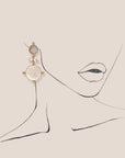 d-by-dalia-jewelry gold drop earrings featuring iridescent mother-of-pearl and crystal accents on a line art portrait