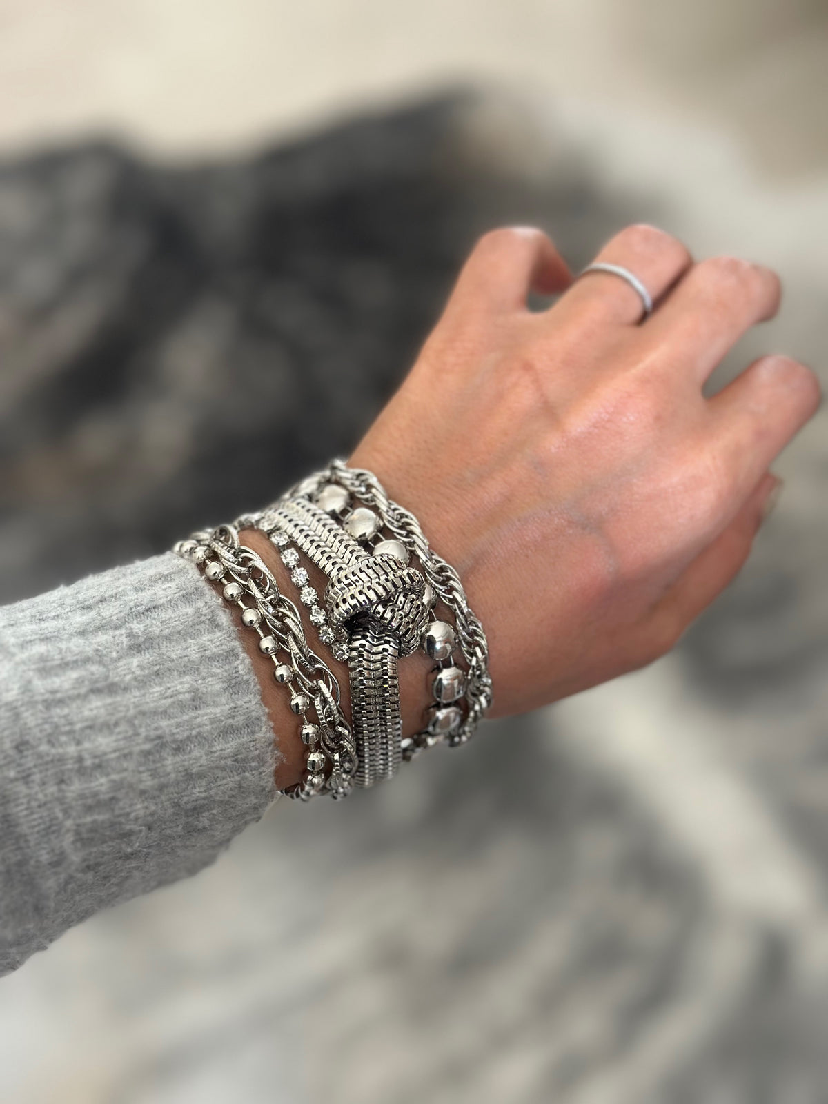 d-by-dalia-jewelry multi-layered silver chain bracelet with a central knotted detail worn on a wrist.