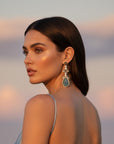 d-by-dalia-jewelry statement drop earrings with carved teardrop gemstone and crystal halo on a model in a silk dress